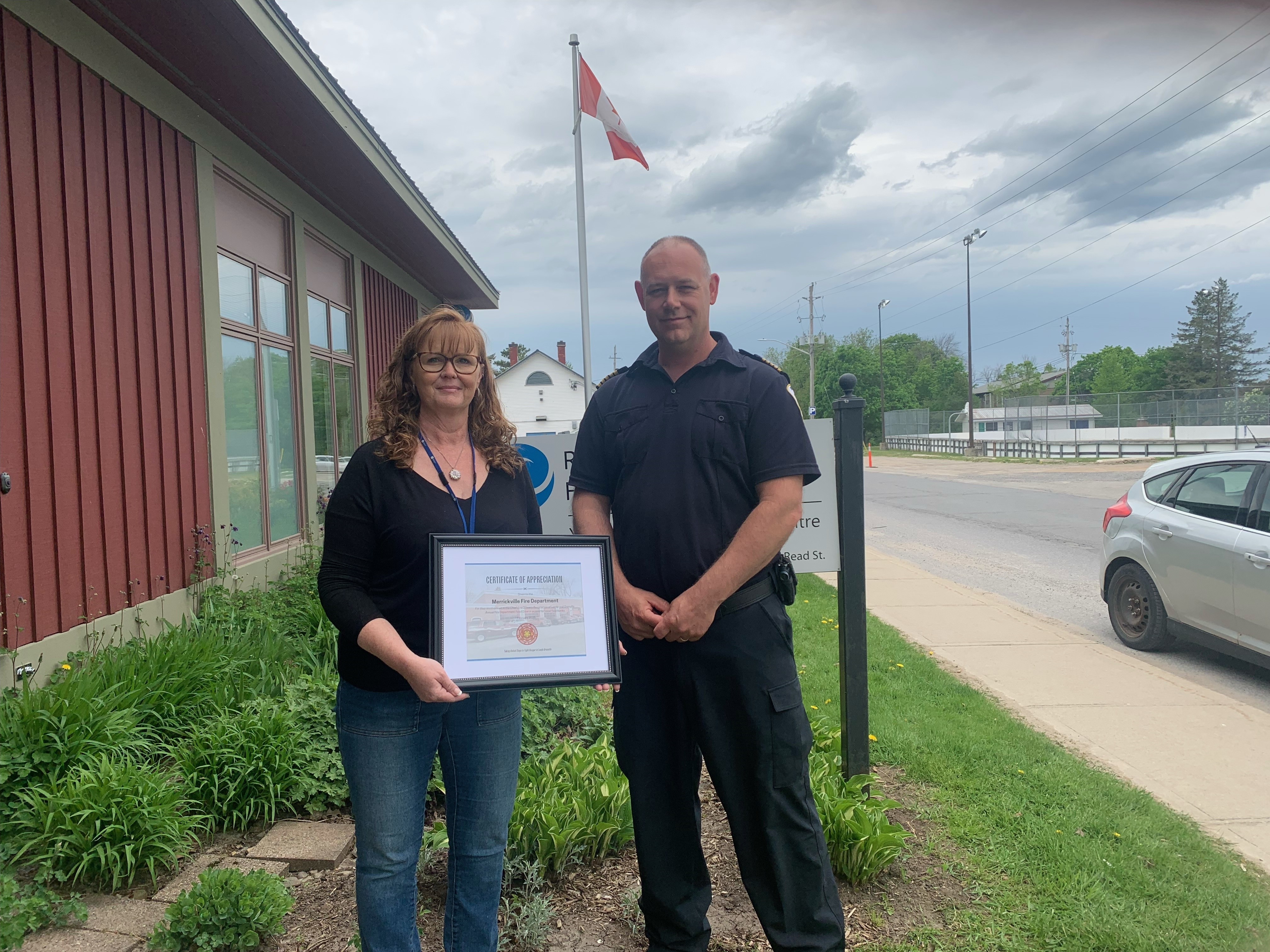 Community Health Worker Joanne Franey presenting a local Fire Chief with a certificate of appreciation for their support during the first annual Fire Department Food Drive. 